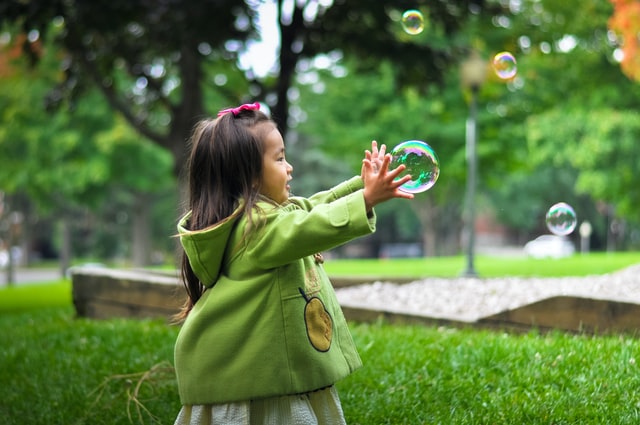 kid playing with a bubble